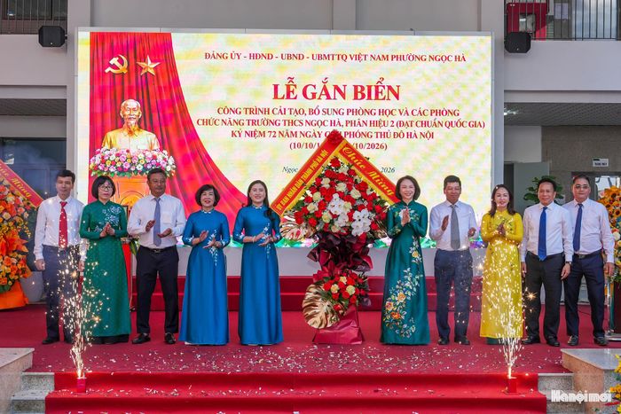 Phó Chủ tịch UBND thành phố Hà Nội Vũ Thu Hà cùng các đại biểu tặng hoa chúc mừng nhà trường.