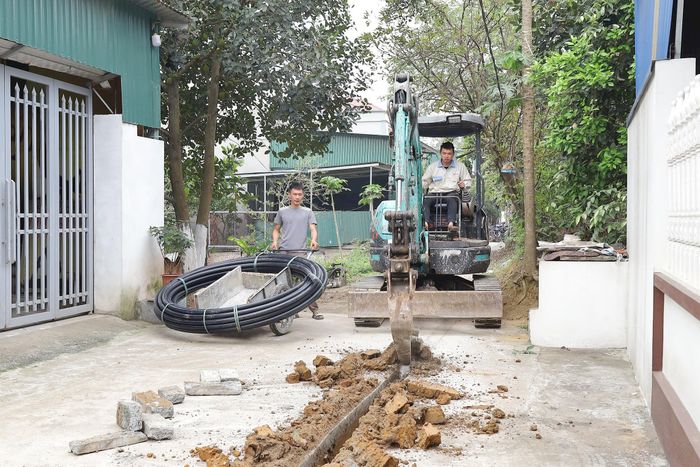 Công nhân Công ty Môi trường đô thị Xuân Mai lắp đặt đường ống cấp nước sạch tại xã Phú Nghĩa. Ảnh: Kim Nhuệ