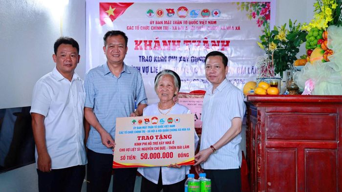 Lãnh đạo Đảng ủy, UBND xã, Ủy ban MTTQ Việt Nam xã trao tặng kinh phí hỗ trợ xây nhà ở cho vợ liệt sĩ tại thôn Bài Lâm. Ảnh: Thanh Hằng