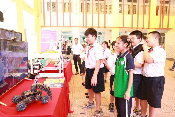 Các em học sinh hào hứng với robot bắt chước chuyển động. Ảnh: N.Vân
