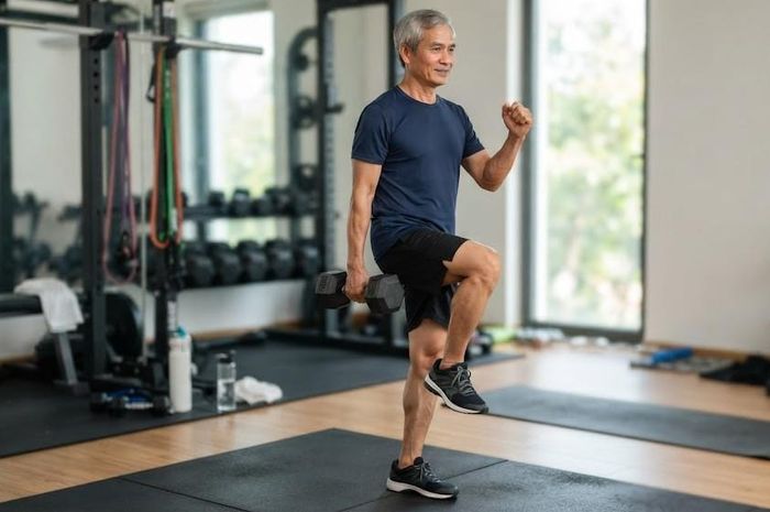 Đi tại chỗ với tạ một tay giúp rèn sức mạnh và khả năng ổn định. Ảnh: AI.