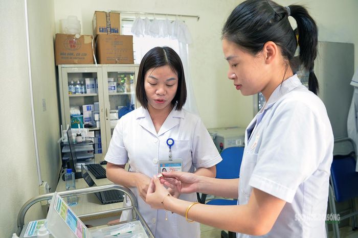 Nhân viên y tế kiểm tra vắc xin trước khi sử dụng. Ảnh: Tuấn Anh