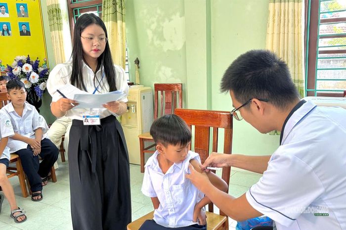 Cán bộ y tế thực hiện tiêm vắc xin cho học sinh tại điểm trường. Ảnh: Trạm y tế xã Vĩnh Thực