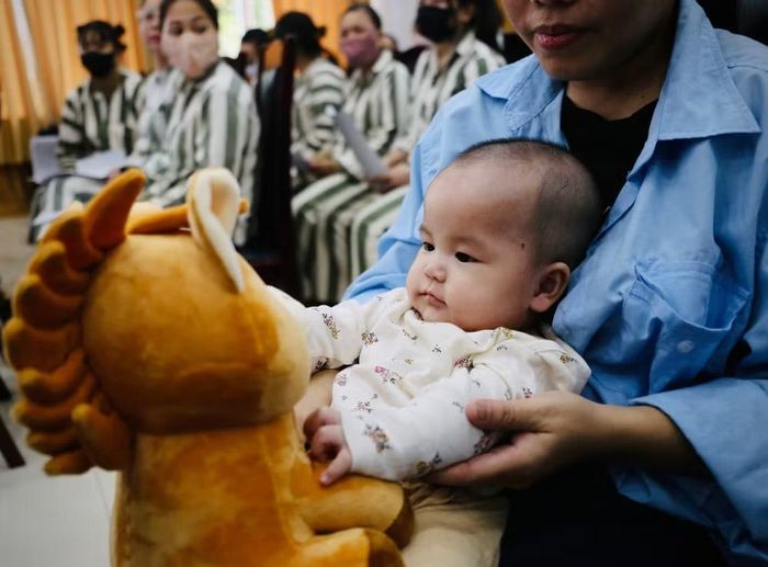 Một em nhỏ thích thú với món quà do các cô chú Công an trao tặng