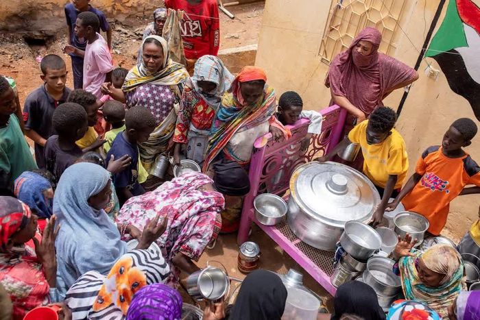  Phụ nữ Sudan từ các bếp ăn cộng đồng do tình nguyện viên địa phương điều hành đang phân phát bữa ăn cho những người bị ảnh hưởng bởi xung đột và nạn đói tại Sudan. Ảnh: Reuters.