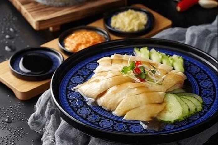  Tại Singapore, cơm gà Hải Nam thường được ăn cùng tương ớt, hỗn hợp gừng và hành lá băm nhuyễn, nước tương đen ngọt và vài lát dưa chuột. Ảnh: Michelin Guide.