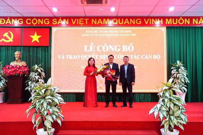 Bà Nguyễn Thanh Xuân, Thành ủy viên, Phó Bí thư Đảng ủy, Trưởng Ban Xây dựng Đảng Đảng ủy UBND TP.HCM và ông Nguyễn Hữu Đạt, Trưởng Cơ quan đại diện Văn phòng Bộ VHTTDL tại TP.HCM trao quyết định và tặng hoa cho ông Vũ Việt Bảo