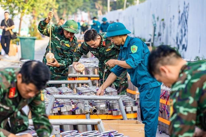 Cán bộ, chiến sĩ và lực lượng dân quân phối hợp lắp đặt các thiết bị tại trận địa pháo hoa, chuẩn bị cho màn trình diễn tối 10/10/2026. Ảnh: TTXVN phát