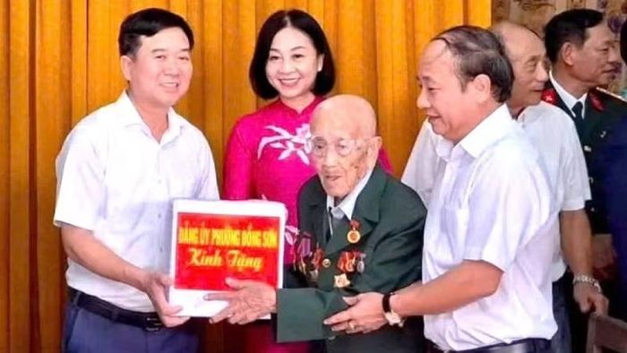 Thường trực Đảng ủy phường Đồng Sơn, tỉnh Quảng Trị tặng quà đảng viên Đinh Hùng Thái tại buổi lễ trao Huy hiệu 80 năm tuổi Đảng cho đồng chí. (Ảnh minh họa: HG)