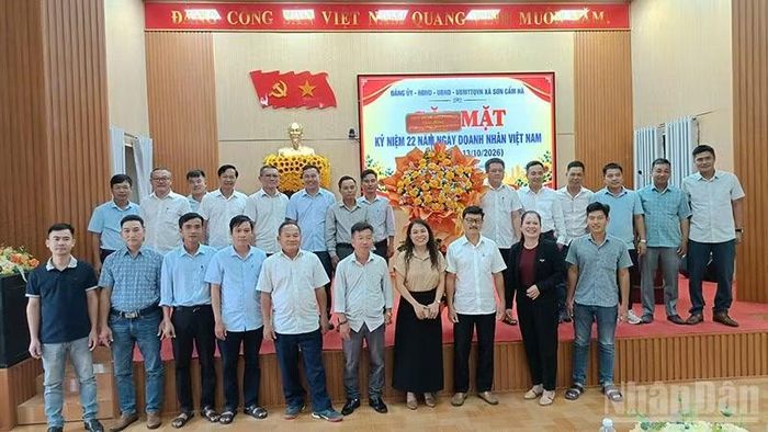 Lãnh đạo xã Sơn Cẩm Hà tặng hoa chúc mừng cộng đồng doanh nghiệp, hợp tác xã và các cơ sở sản xuất, kinh doanh trên địa bàn. (Ảnh: QV)