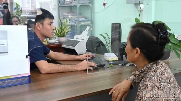 Người dân được cán bộ Trung tâm Phục vụ hành chính công phường Bình Minh hỗ trợ làm thủ tục hành chính. (Ảnh: THANH PHONG)