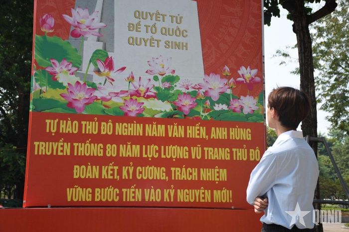 Bạn trẻ dừng chân ngắm nhìn pa-nô tuyên truyền, cổ vũ tinh thần và trách nhiệm hướng tới kỷ nguyên mới. Ảnh: BẢO KHÁNH