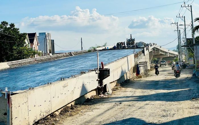 Đoạn cầu vượt đường sắt (xã Thăng Bình) tiến hành tưới nhựa trước khi thảm bê – tông nhựa.