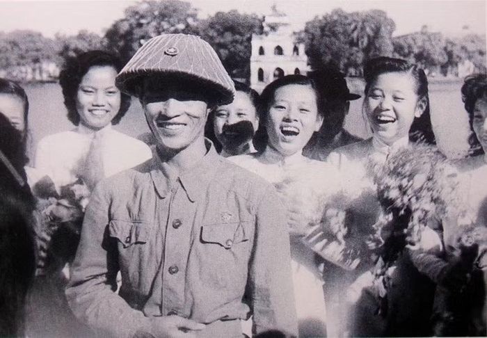 Trung tướng Vương Thừa Vũ dẫn đầu Đại đoàn Quân Tiên Phong về tiếp quản Thủ đô bên hồ Hoàn Kiếm trong sự chào đón của các thiếu nữ Hà Nội. Ảnh tư liệu