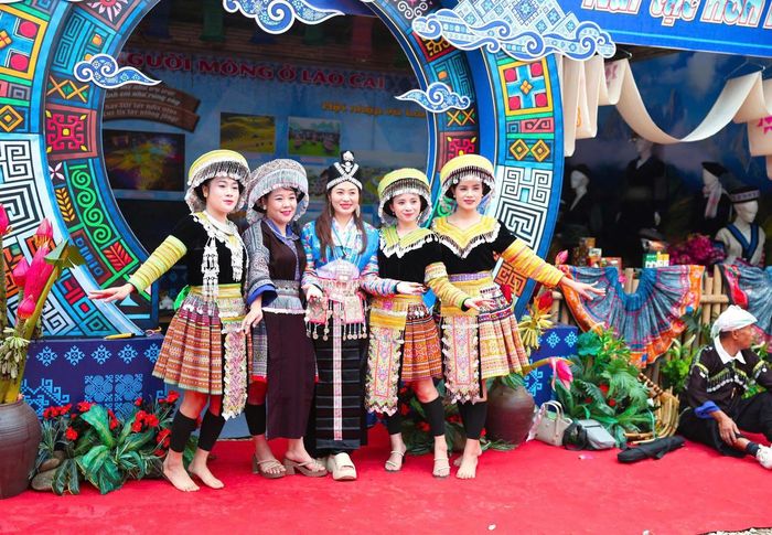 Phụ nữ dân tộc Mông và du khách trong trang phục truyền thống (Ảnh: CTV).