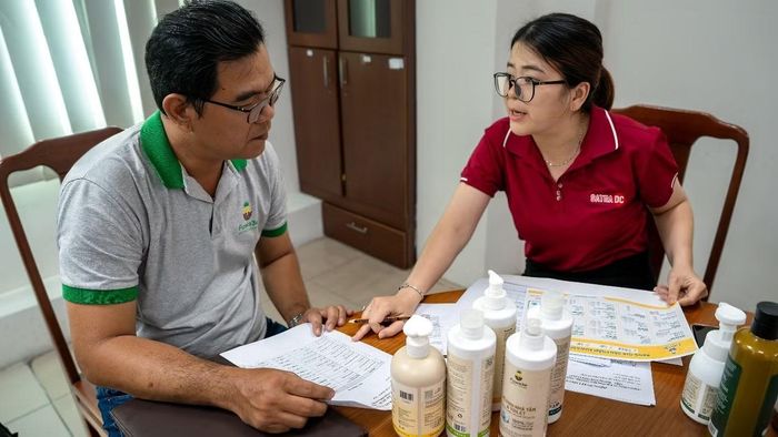 Nhân viên Trung tâm Phân phối SATRA đang hướng dẫn doanh nghiệp các thủ tục cần thiết để đăng ký, đưa hàng vào hệ thống bán lẻ SATRA. Ảnh: SATRA