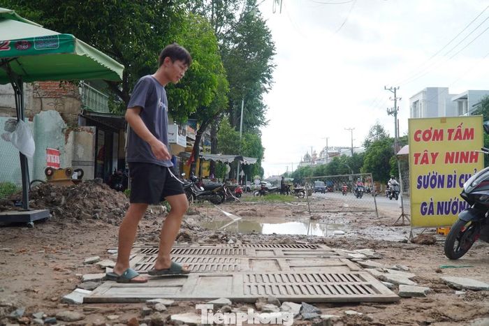 Người dân phải bắc ván vượt qua rãnh đào để ra vào nhà, cửa hàng trong thời gian công trình thi công. Ảnh: Nguyễn Tiến