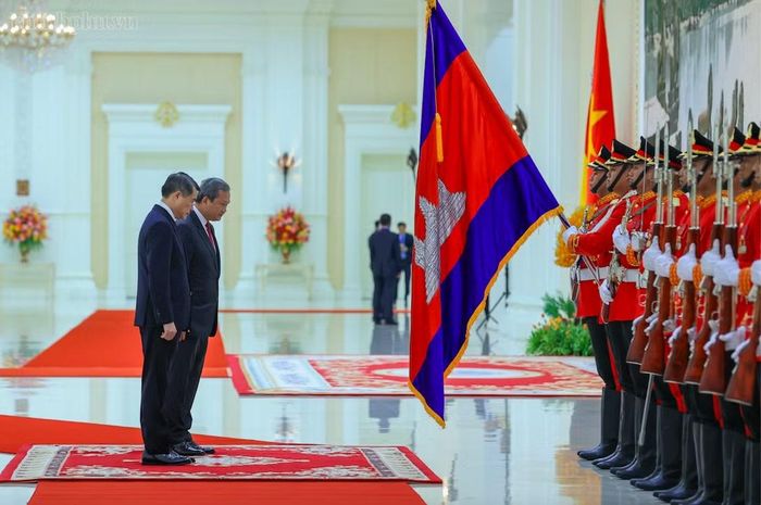 Hai Thủ tướng cúi chào trước quân kỳ. Ảnh: VGP