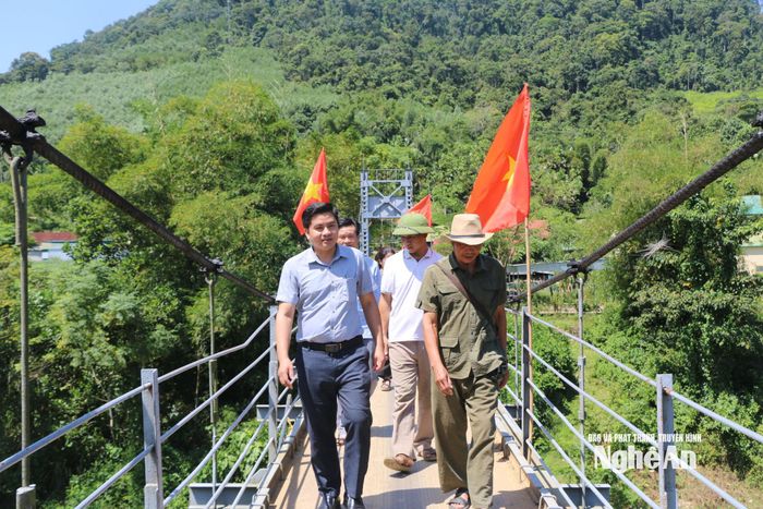 Bí thư Chi bộ bản Cươm (đội mũ, bên phải) dẫn lãnh đạo Ban xây dựng Đảng xã Hùng Chân vào thăm bản. Ảnh: K.L