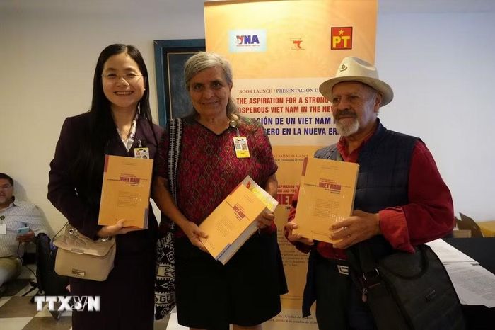 Các đại biểu cầm trên tay cuốn sách “Khát vọng Việt Nam hùng cường trong kỷ nguyên mới’’ tập hợp các bài viết, phát biểu tiêu biểu của Tổng Bí thư, Chủ tịch nước Tô Lâm. (Ảnh: Phi Hùng/TTXVN)