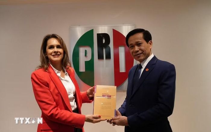 Phó Giám đốc Học viện Chính trị quốc gia Hồ Chí Minh Hoàng Phúc Lâm tặng cuốn sách “Khát vọng Việt Nam hùng cường trong kỷ nguyên mới’’ cho bà Sofia Carvajal, Chủ nhiệm Ủy ban Đối ngoại Đảng Cách mạng Thể chế (PRI). (Ảnh: Phi Hùng/TTXVN)