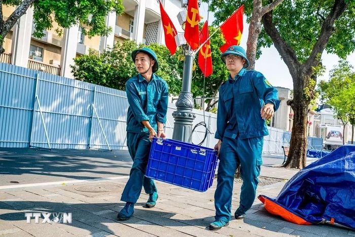 Lực lượng dân quân tham gia vận chuyển thiết bị phục vụ công tác chuẩn bị bắn pháo hoa chào mừng 72 năm Ngày Giải phóng Thủ đô. (Ảnh: TTXVN phát)