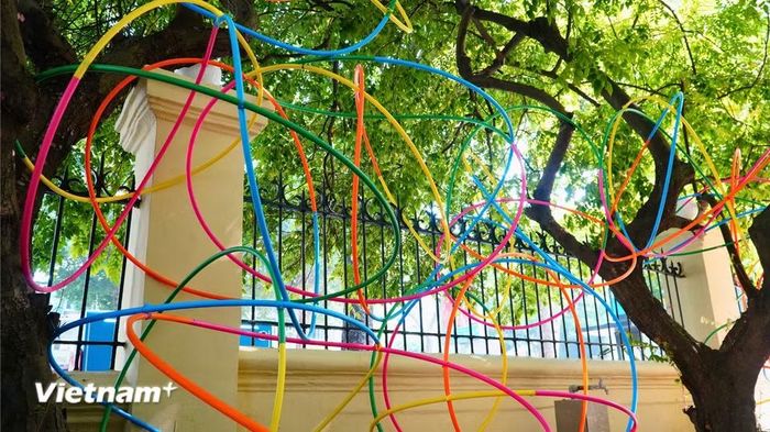 Những dải vòng nhựa uốn lượn kết nối từ trong phòng trưng bày ra đến khoảng sân vườn ngoài trời. (Ảnh: Ngân Bình/Vietnam+)