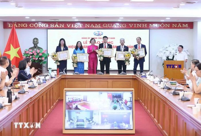 Đồng chí Vũ Việt Trang, Ủy viên Ban Thường vụ Đảng ủy các cơ quan Đảng Trung ương, Bí thư Đảng ủy, Tổng Giám đốc Thông tấn xã Việt Nam, Phó Trưởng ban Tuyên giáo Trung ương trao Huy hiệu cho các đồng chí 40 năm; 35 năm và 30 năm tuổi Đảng. (Ảnh: An Đăng/TTXVN)