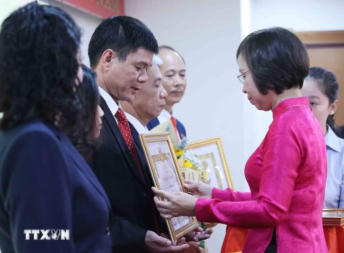 Đồng chí Vũ Việt Trang, Ủy viên Ban Thường vụ Đảng ủy các cơ quan Đảng Trung ương, Bí thư Đảng ủy, Tổng Giám đốc Thông tấn xã Việt Nam, Phó Trưởng ban Tuyên giáo Trung ương trao Huy hiệu cho các đồng chí 40 năm; 35 năm và 30 năm tuổi Đảng. (Ảnh: An Đăng/TTXVN)
