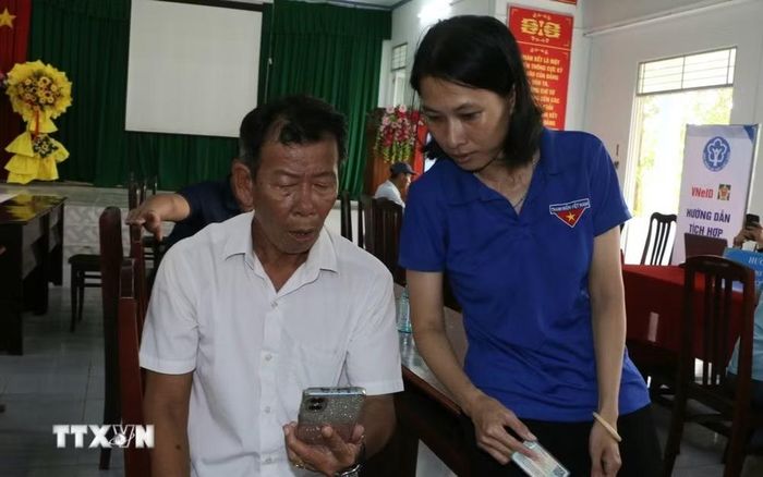 Công an xã, đoàn thể, doanh nghiệp viễn thông, ngân hàng và Tổ Công nghệ số cộng đồng, hướng dẫn người dân góp phần đưa các tiện ích số đến gần hơn với từng hộ dân. (Ảnh: Duy Khương/TTXVN)