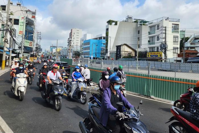 Các phương tiện lưu thông trên đường Cách Mạng Tháng Tám hướng về vòng xoay Dân Chủ.