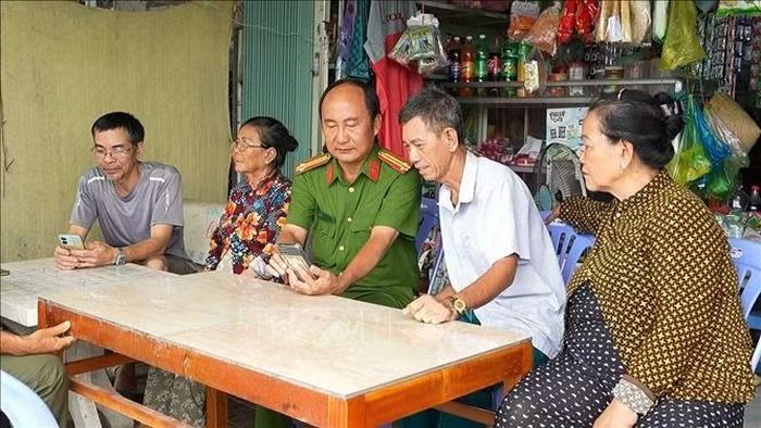 Người dân phường Vị Tân, thành phố Cần Thơ, tìm hiểu cách sử dụng ứng dụng VNEID với sự hướng dẫn của cán bộ Công an phường. Ảnh tư liệu: TTXVN phát