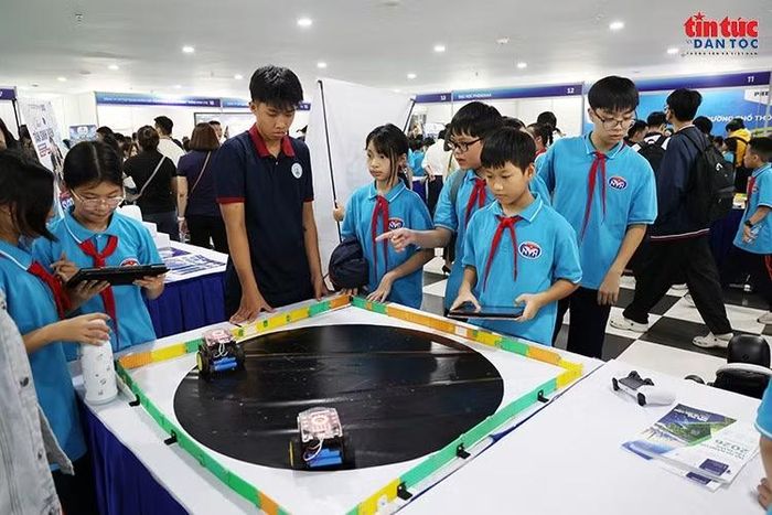 Học sinh chăm chú điều khiển robot trên sa bàn, rèn luyện tư duy logic và kỹ năng tương tác với công nghệ.