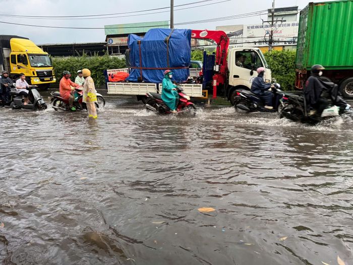 Đội Cảnh sát giao thông An Sương tổ chức điều tiết, hướng dẫn phương tiện, hỗ trợ người dân lưu thông an toàn qua khu vực thi công nút giao Ngã tư Đình khi xảy ra ngập nước do mưa lớn.
