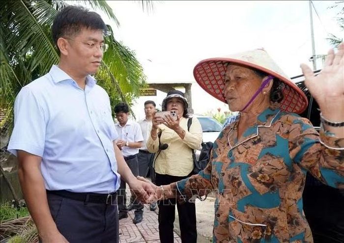 Phó Chủ tịch Ủy ban nhân dân tỉnh Quảng Ngãi Đỗ Tâm Hiển (bên trái ảnh) động viên người dân vùng bị ngập nặng.