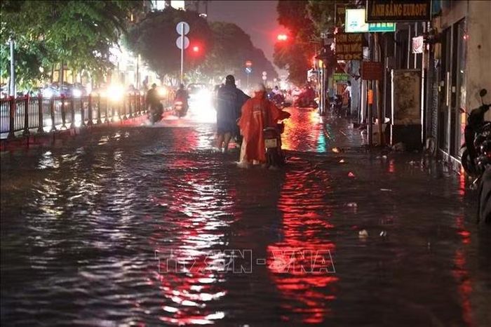Xe chết máy, người dân phải dắt bộ qua đoạn ngập trên đường Phan Văn Trị, phường Hạnh Thông, tối 7/10.
