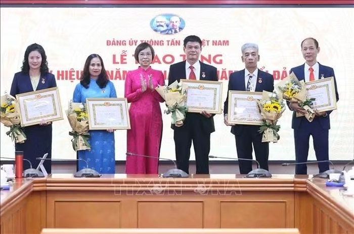 Đồng chí Vũ Việt Trang, Ủy viên Ban Thường vụ Đảng ủy các cơ quan Đảng Trung ương, Bí thư Đảng ủy, Tổng Giám đốc Thông tấn xã Việt Nam, Phó Trưởng ban Tuyên giáo Trung ương trao Huy hiệu cho các đồng chí 40 năm; 35 năm và 30 năm tuổi Đảng. Ảnh: An Đăng/TTXVN
