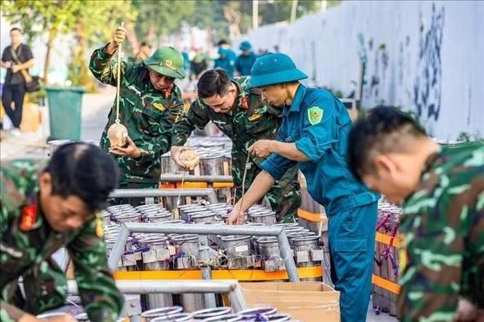 Cán bộ, chiến sĩ và lực lượng dân quân phối hợp lắp đặt các thiết bị tại trận địa pháo hoa, chuẩn bị cho màn trình diễn tối 10/10/2026. Ảnh: TTXVN phát