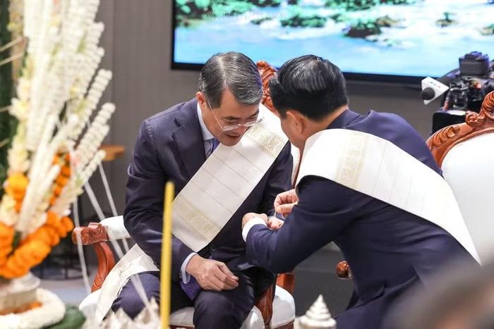  Thủ tướng Chính phủ Lào Saleumxay Kommasith buộc chỉ cổ tay cho Thủ tướng Lê Minh Hưng. Ảnh: chinhphu.vn/Nhật Bắc. 