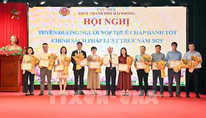 Ông Nguyễn Tiến Trường, Trưởng Thuế thành phố Hải Phòng, trao Bằng khen, Giấy khen cho 135 người nộp thuế tiêu biểu xuất sắc. Ảnh: Hoàng Ngọc - TTXVN