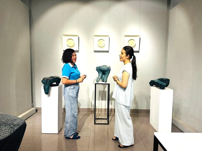 Chị Nguyễn Thị Mai Anh, Chi hội trưởng phụ nữ thôn Giang Cao trao đổi cùng chị Đỗ Minh Tâm trong không gian trưng bày các tác phẩm gốm điêu khắc của gia đình.