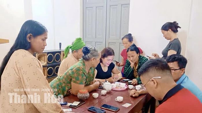 Chị Lữ Thị Thanh (mặc áo đen), Bí thư Chi bộ thôn Quạn, xã Vạn Xuân hỗ trợ NCT cài đặt và sử dụng các ứng dụng số cơ bản.