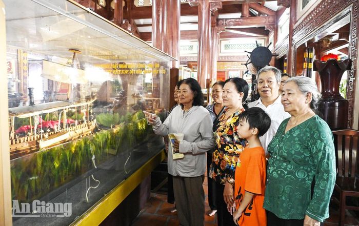 Một gia đình ở Long Xuyên đến dâng lễ và tham quan nhà trưng bày tại Di tích lịch sử - văn hóa mộ và đình Nguyễn Trung Trực.