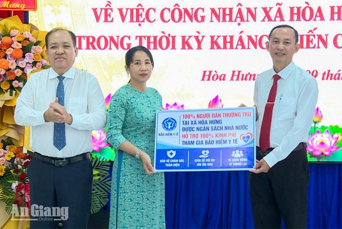Trao bảng tượng trưng hỗ trợ 100% kinh phí tham gia bảo hiểm y tế cho người dân trên địa bàn xã.