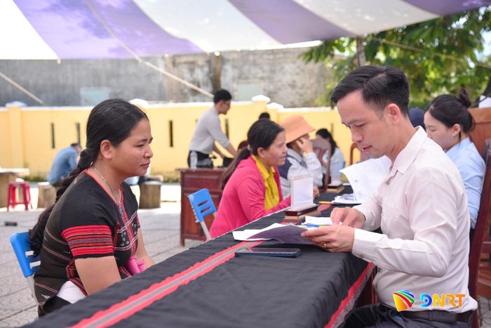 Lực lượng chức năng hướng dẫn người dân kê khai, kiểm tra giấy tờ và tiếp nhận hồ sơ đề nghị cấp giấy chứng nhận quyền sử dụng đất lần đầu. Ảnh: XUÂN DŨNG