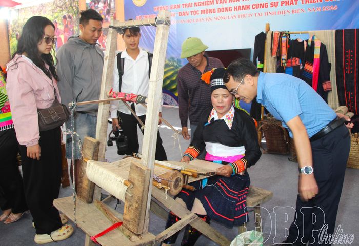 Du khách tìm hiểu nghề dệt vải truyền thống bằng sợi lanh của đồng bào Mông.