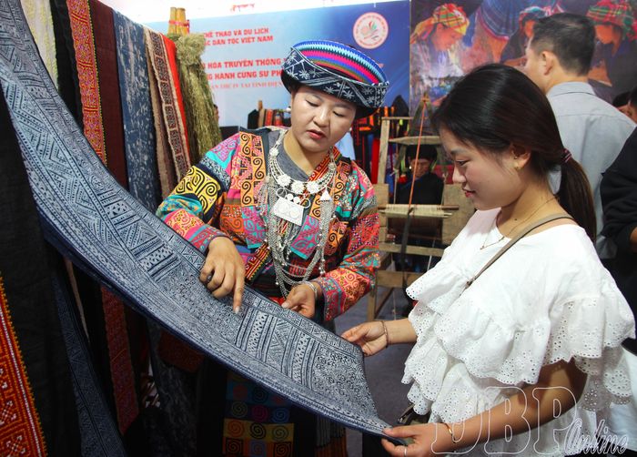 Chị Sùng Thị Dính giới thiệu tới du khách sản phẩm dệt thủ công truyền thống.