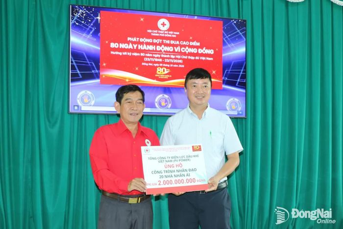 Đại diện Tổng công ty Điện lực dầu khí Việt Nam trao bảng tượng trưng ủng hộ xây dựng 20 ngôi nhà nhân ái cho Hội Chữ thập đỏ thành phố Đồng Nai. Ảnh: Vương Thế