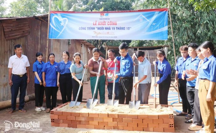 Các đại biểu thực hiện nghi thức khởi công "Ngôi nhà 15 tháng 10" cho gia đình chị Thị Lan (áo nâu, ở giữa) tại xã Minh Đức. Ảnh: Ngọc Huyền