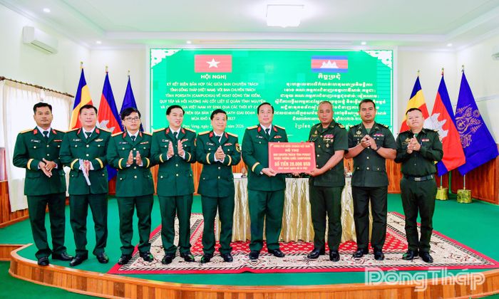 Đại tá Nguyễn Văn Hoa, Chính ủy Bộ Chỉ huy Quân sự tỉnh Đồng Tháp thừa ủy quyền của Ban Chuyên trách Chính phủ Việt Nam trao kinh phí hỗ trợ Ban Chuyên trách tỉnh Pursat trong công tác phối hợp tìm kiếm, quy tập, hồi hương hài cốt liệt sĩ quân tình nguyện và chuyên gia Việt Nam hy sinh trong các thời kỳ chiến tranh tại Campuchia. .